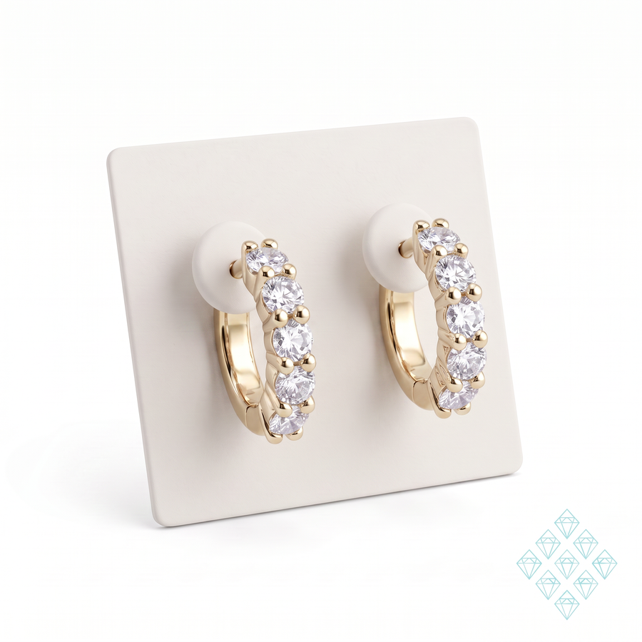 Boucles d'oreilles Aquira en vermeil or 18 carats sur argent 925 posées sur un présentoir carré ivoire